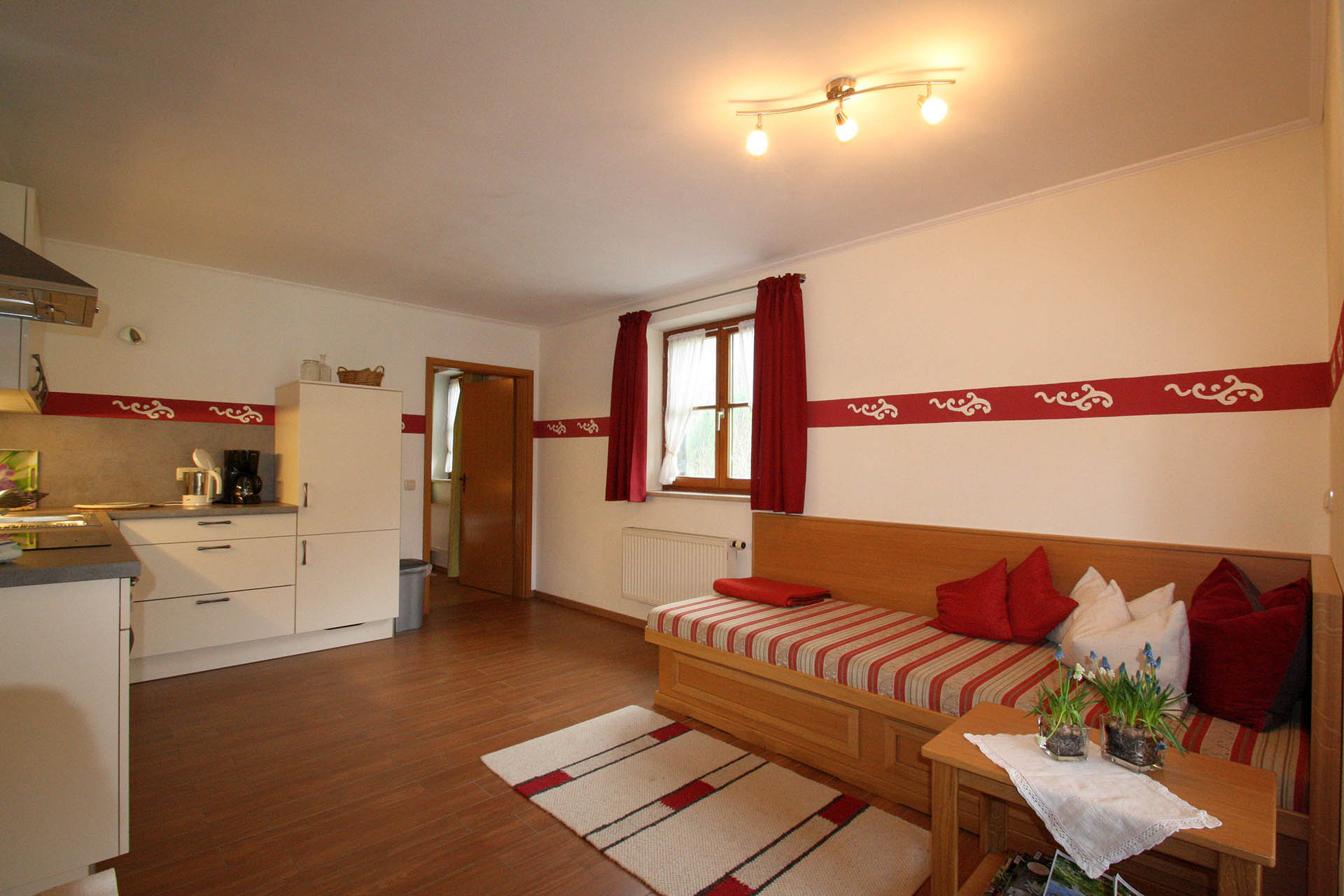 Wohnbereich mit Essecke, Couch und Küche in der Ferienwohnung Sulzberg